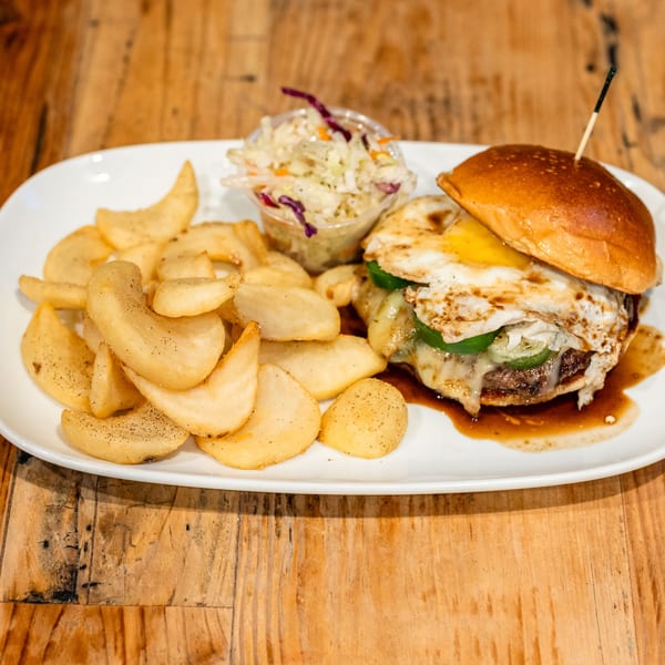 David Alan Alan's Smokehouse & Saloon's BBQ burger with a fried egg, jalapeños, fries, and coleslaw.